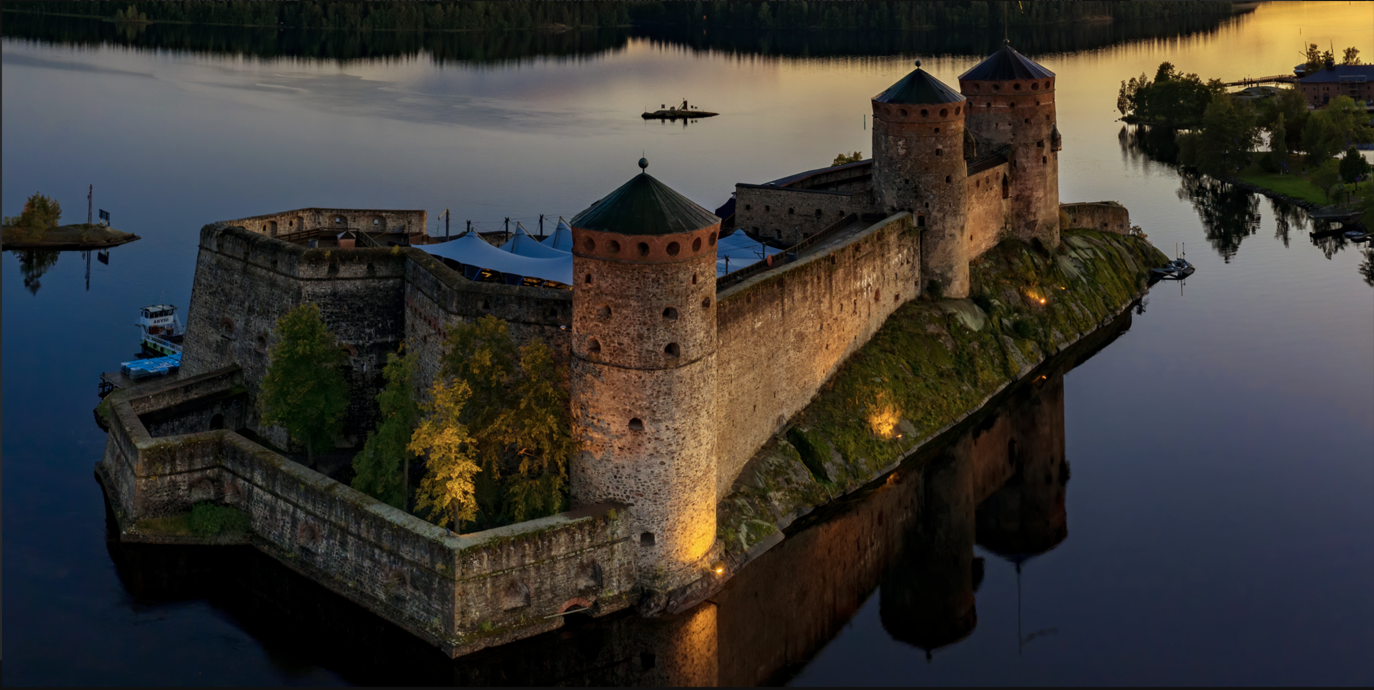 The Olavinlinna Castle is seen at twilight in late summer.